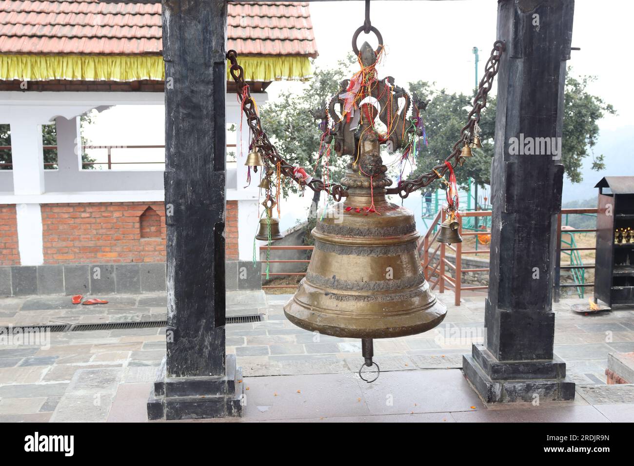 Vue rapprochée d'une cloche de temple faite de matériau de bronze, accrochée entre deux piliers Banque D'Images