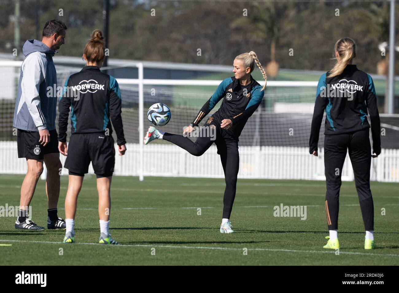 Tuggerah, Australie. 22 juillet 2023. Football : coupe du monde, femmes, entraînement Allemagne : la gardienne Merle Frohms (M) joue un ballon entre Michael Fuchs (G-D), entraîneur de l'équipe nationale allemande féminine de football, Lina Magull et Laura Freigang. Crédit : Sebastian Gollnow/dpa/Alamy Live News Banque D'Images