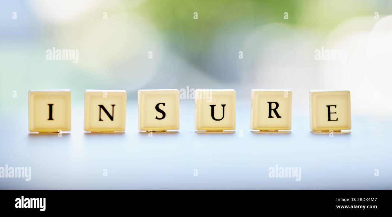 Lettres, blocs et un message d'assurance sur un bureau pour affaires, sécurité ou finance avec bokeh. bannière, maquette et un mot sur une table à un financier Banque D'Images