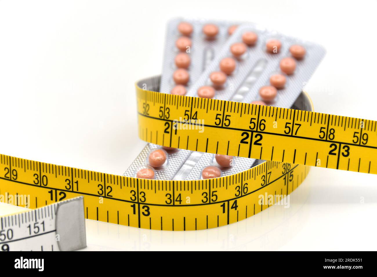 Bandelettes contraceptives et bandelettes jaunes sur fond blanc dans le concept de contrôle du poids. Banque D'Images