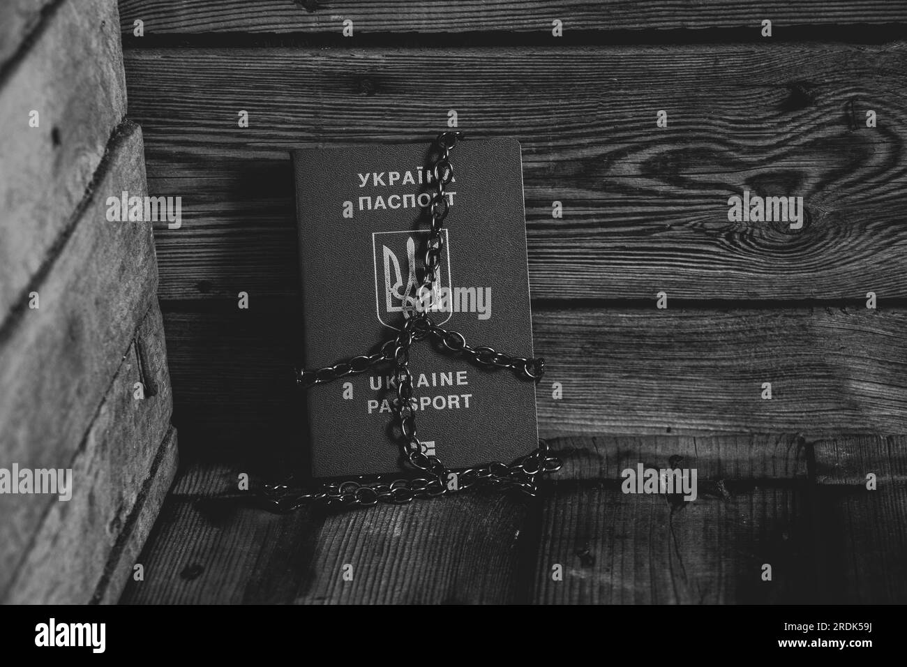 Un passeport biométrique étranger de l'Ukraine attaché avec des stands de chaîne est un coin sur une planche , une arrestation et une interdiction de l'ukrainien , un réfugié est également arrêté Banque D'Images