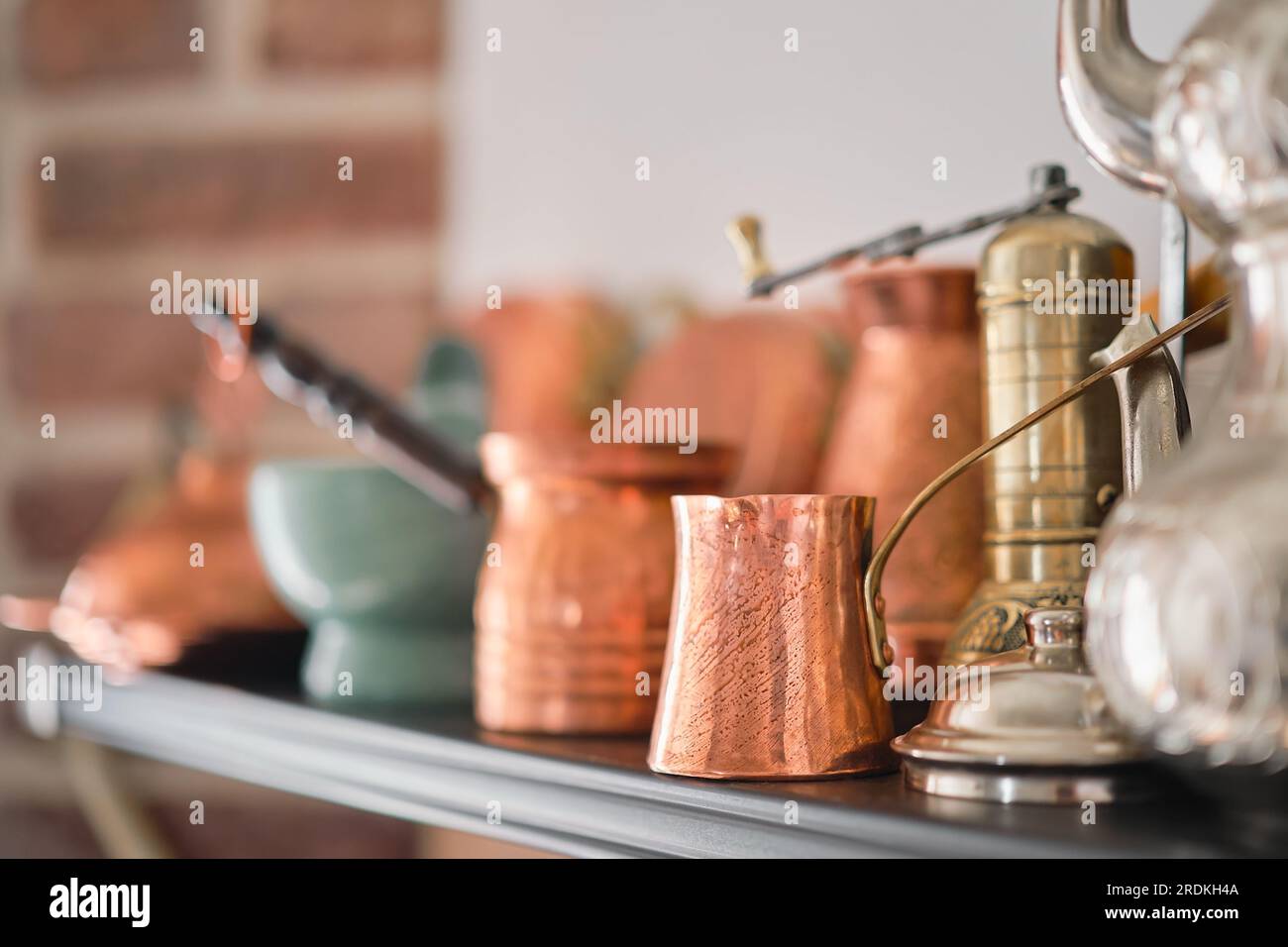 Cezve en cuivre fait à la main, vaisselle traditionnelle turque sur une étagère dans la cuisine à la maison ou dans un restaurant, mise au point sélective Banque D'Images