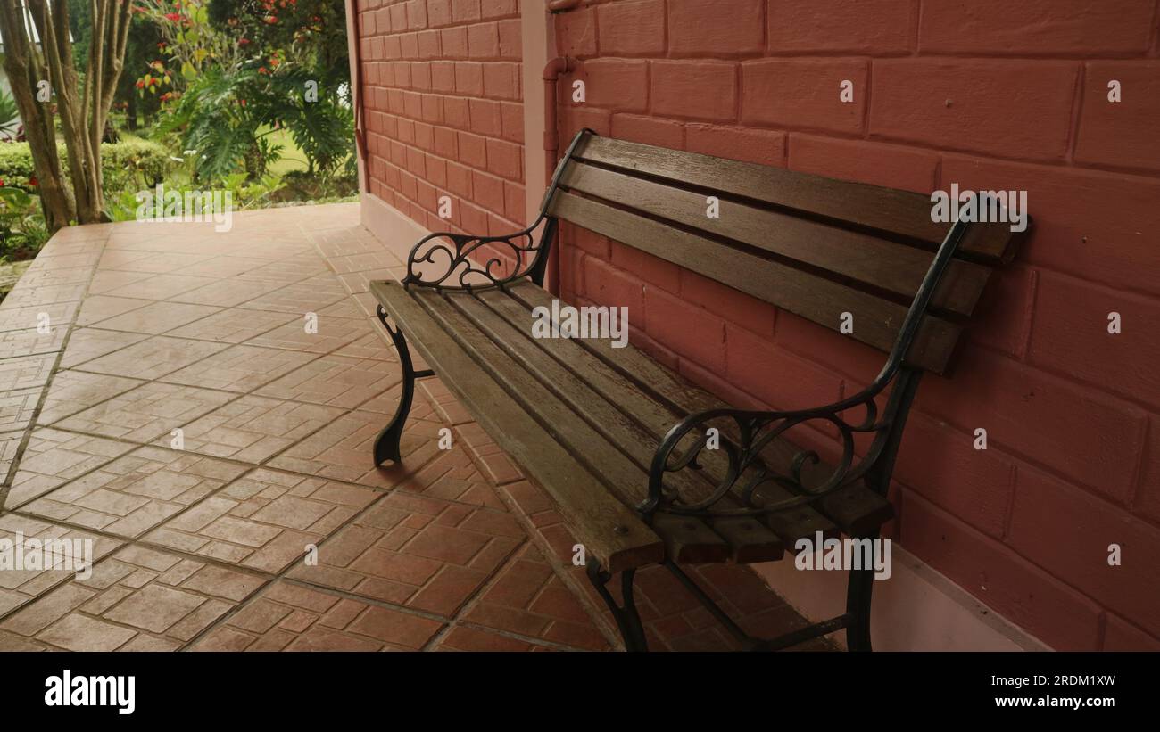 Chaise en bois à la terrasse de la maison avec mur de briques rouges Banque D'Images