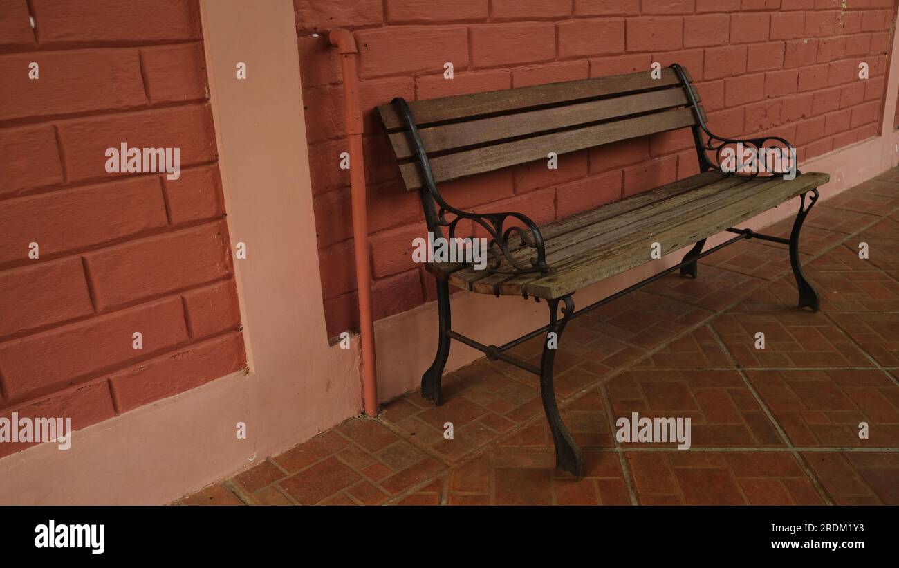 Chaise en bois à la terrasse de la maison avec mur de briques rouges Banque D'Images