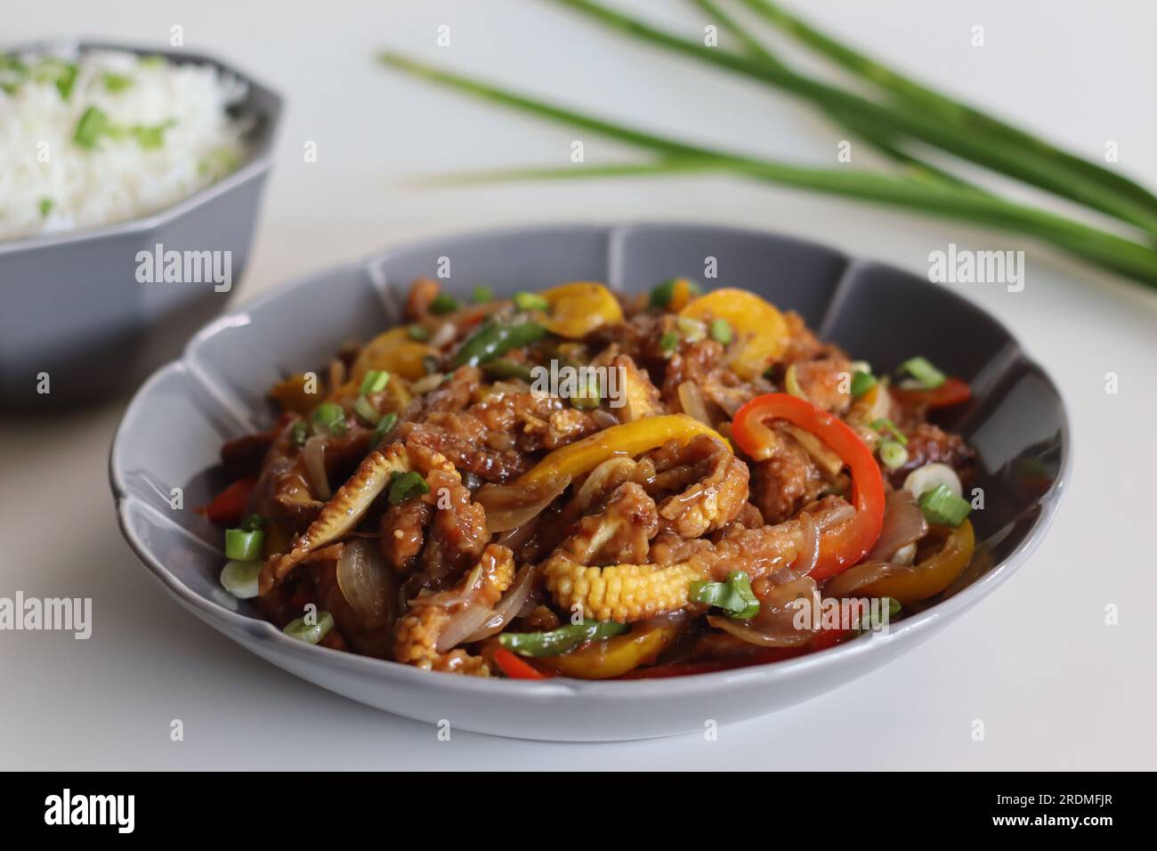 Bébé maïs frais servi avec riz au beurre avec oignons de printemps. Un plat indo-chinois avec du maïs frit croustillant dans une sauce épicée avec de l'oignon sauté Banque D'Images