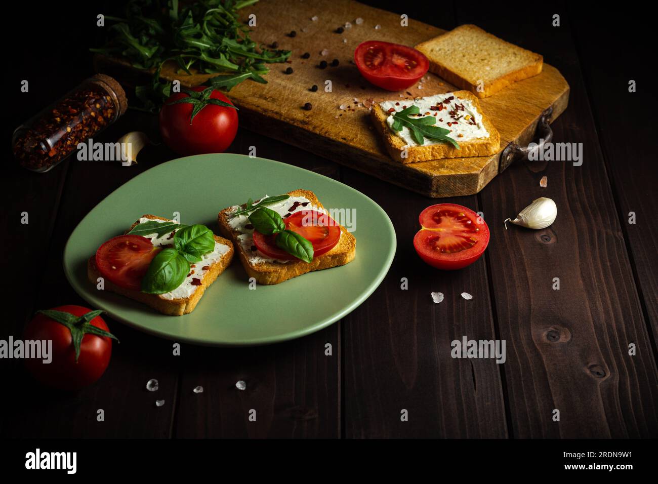 Cuisson des sandwichs avec des légumes pour le petit déjeuner ensemble à la table en bois. Fond en bois Banque D'Images