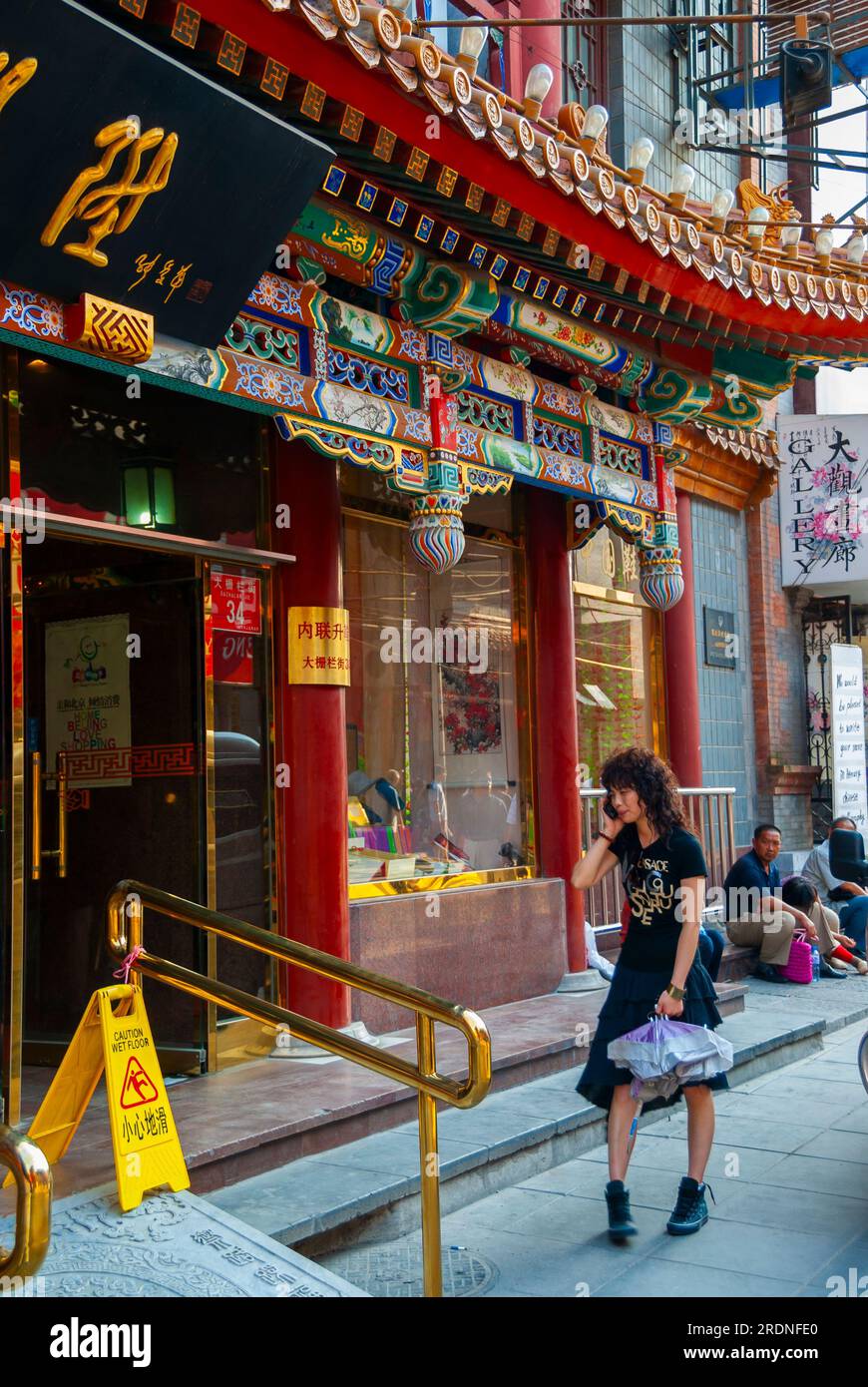 Pékin, CHINE- femme marchant seule, parler au téléphone, Shopping, extérieur, rue Dashilan, « Neiliansheng' Chaussure Store, dans la zone de Qianmen, façade, façade d'architecture traditionnelle, hutongs chinois de la vieille ville de pékin Banque D'Images