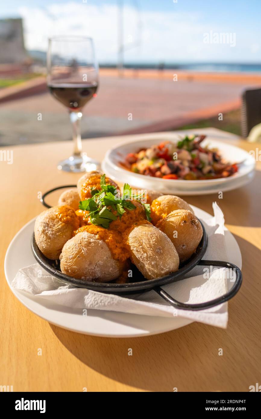 Plat des îles Canaries Papas arrugadas pommes de terre richement salées avec et sauce épicée rouge Mojo picon. Banque D'Images