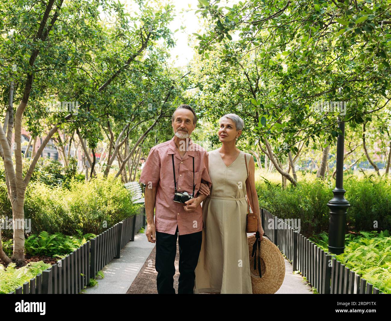 Touristes matures marchant dans le parc. Couple senior marchant ensemble dans le parc pendant la journée. Banque D'Images