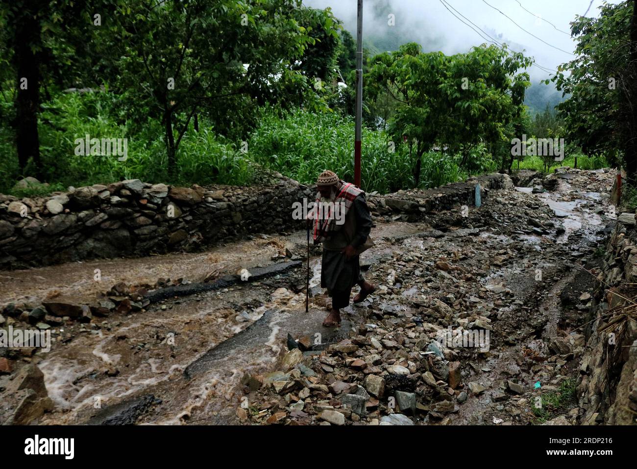 22 juillet 2023, Srinagar Cachemire, Inde : un homme cachemirien âgé marche le long d'une route vallonnée endommagée à la suite de crues soudaines dans la région de Faqir Gujri, à la périphérie de Srinagar. Les habitants ont affirmé que plusieurs maisons avaient développé des fissures et que les champs de maïs avaient été endommagés, mais aucune victime n'a été signalée. Des pluies abondantes et continues ont frappé diverses régions du Jammu-et-Cachemire, provoquant de multiples glissements de terrain dans les zones vallonnées et entraînant la fermeture de la route nationale Jammu-Srinagar. Le 22 juin 2023 à Srinagar Cachemire, Inde. (Image de crédit : © Firdous Nazir/eyepix via ZUMA Press Wire) EDI Banque D'Images