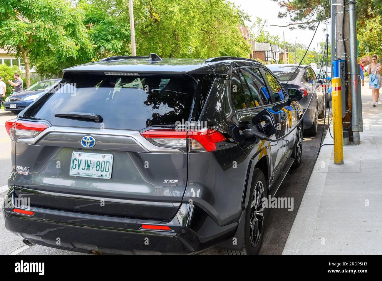 Toronto, Canada - 9 juillet 2023 : une voiture électrique Toyota est chargée à partir d'un chargeur dans une rue de la ville. Banque D'Images