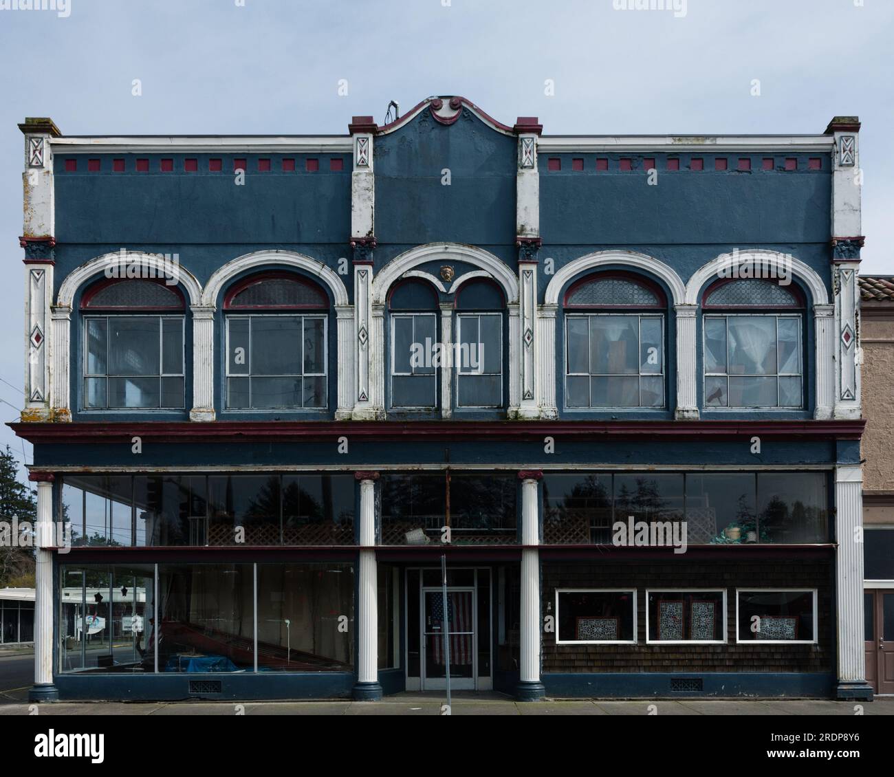 Vitrine abandonnée avec façade en fonte dans une petite ville sur la côte Pacifique, Ilwaco, Washington, États-Unis. Banque D'Images