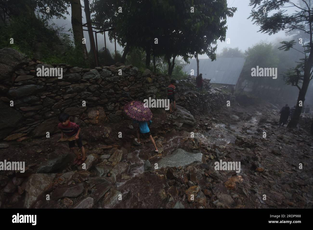 Srinagar, Inde. 22 juillet 2023. Des villageois cachemiris marchent sur une route endommagée par des crues soudaines après un nuage à la périphérie de Srinagar, Cachemire contrôlé par les Indiens, samedi 22 juillet 2023. Des crues soudaines et des nuages dans le Cachemire indien ont endommagé les cultures et coupé les routes. Aucune victime n ' a été signalée. (Photo de Mubashir Hassan/Pacific Press) crédit : Pacific Press Media production Corp./Alamy Live News Banque D'Images