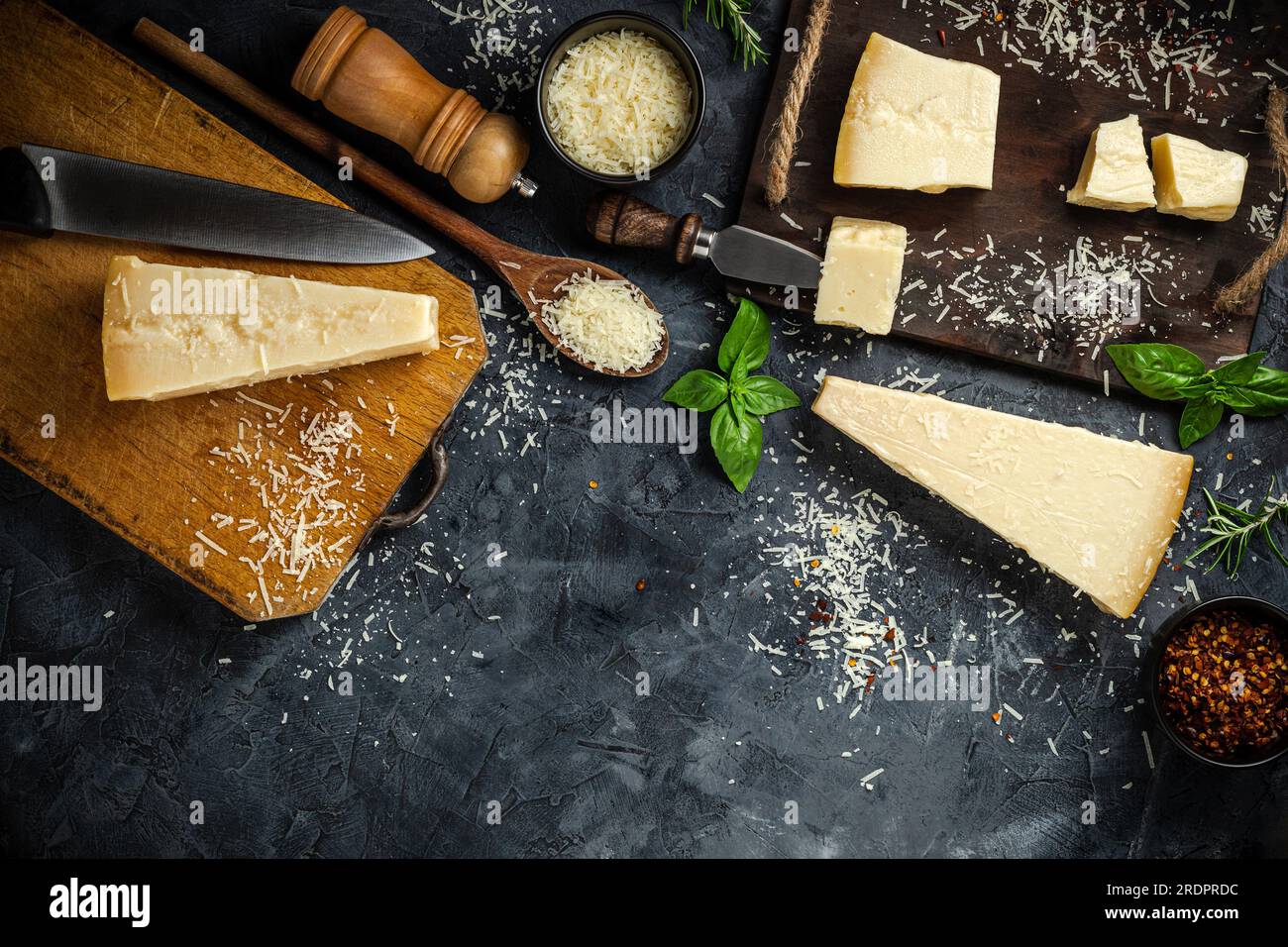 Jeu de fromages à pâte dure avec couteaux à fromage sur fond de pierre noire. Parmesan. Vue de dessus. Espace libre pour votre texte. Banque D'Images