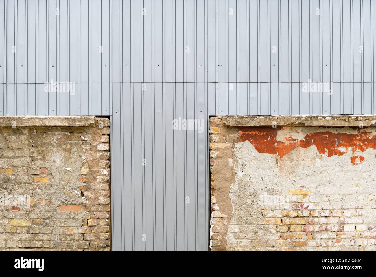 Vieux bâtiment industriel en ruine fermé avec des plaques de tôle ondulée comme arrière-plan Banque D'Images