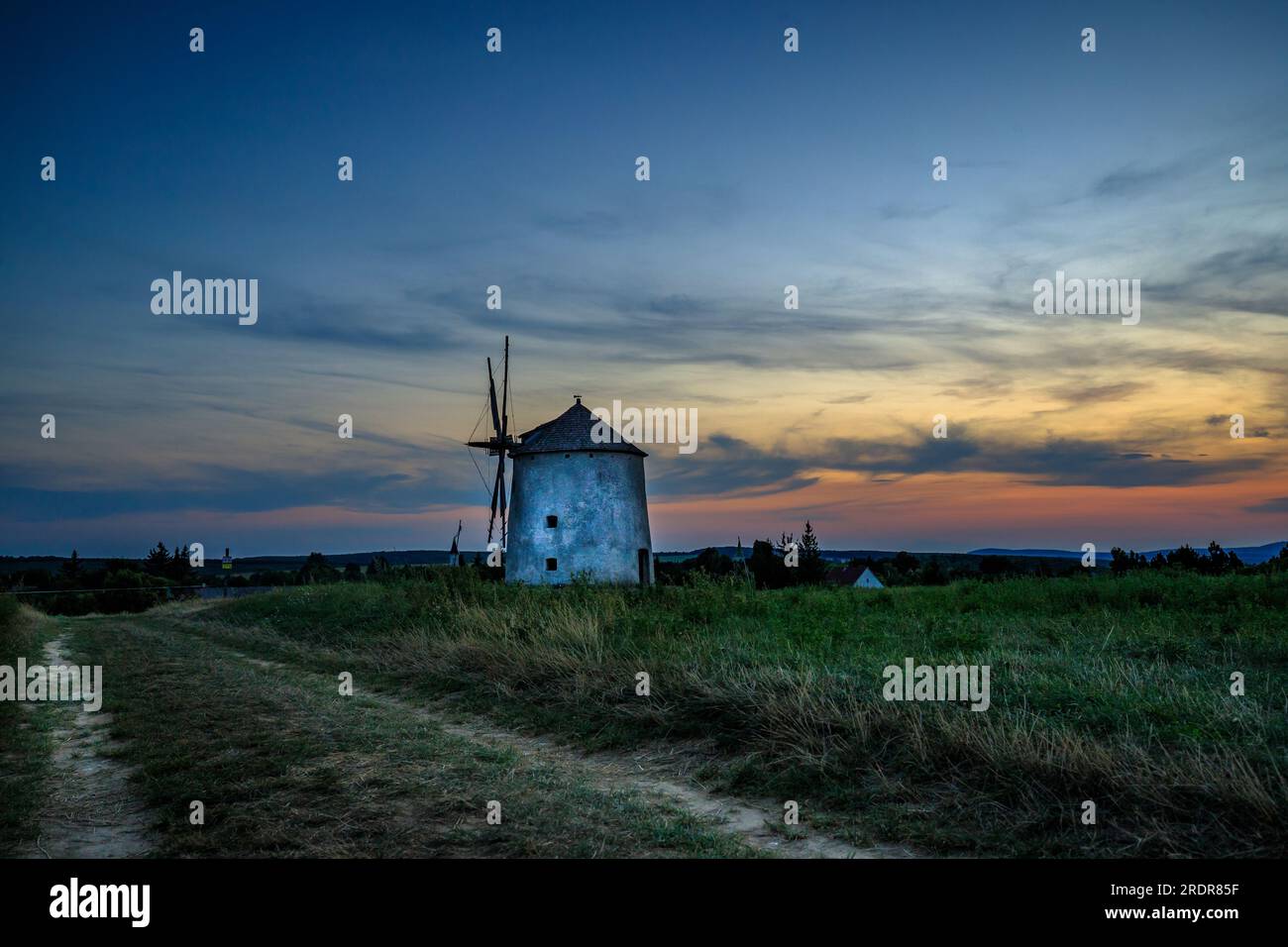 Moulin à vent au coucher du soleil avec des fleurs. Dans la soirée, ces moulins sont dans un grand paysage en Hongrie à tes am Balaton Banque D'Images