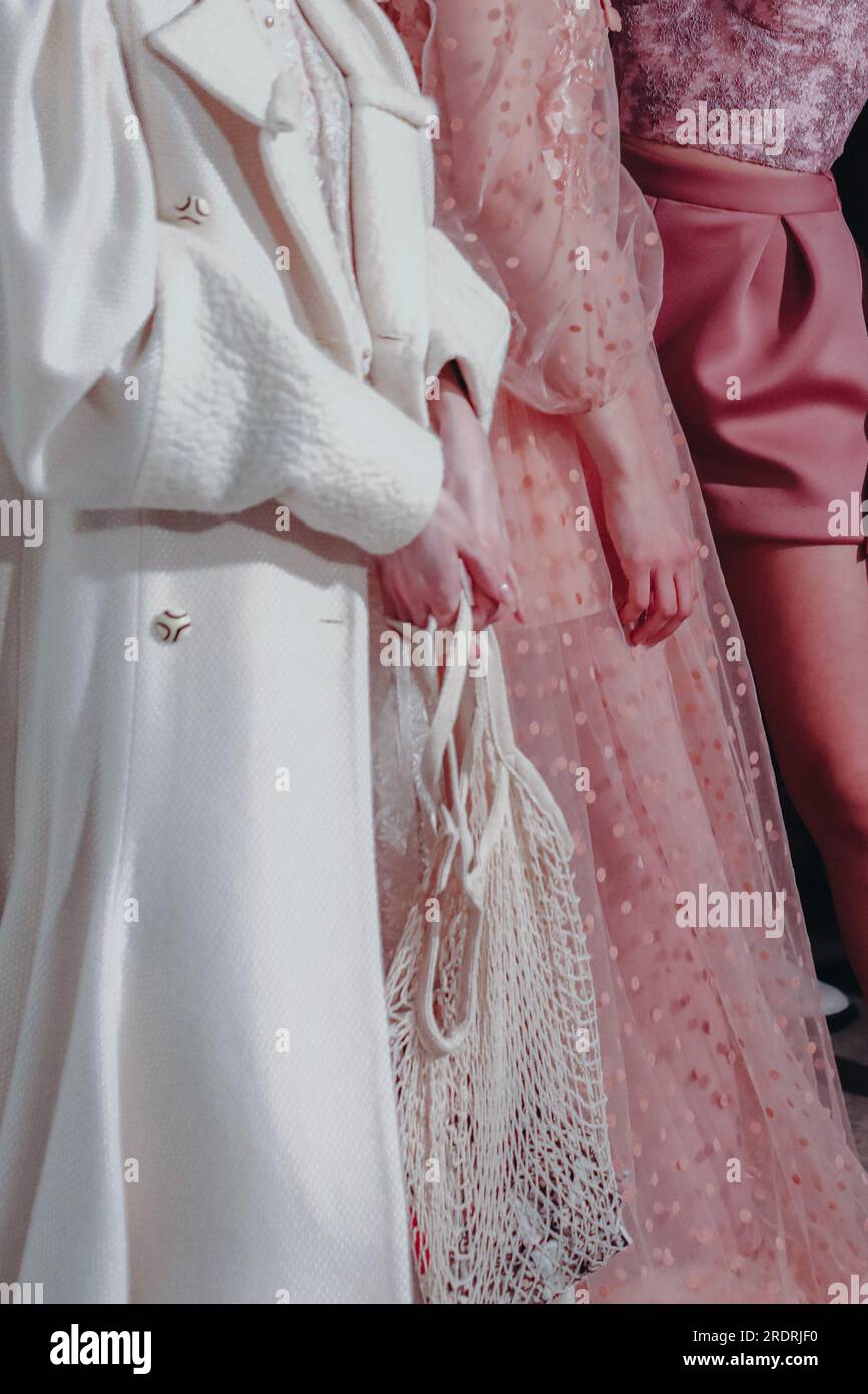 Figurines féminines recadrées en manteau blanc et robe rose sur les coulisses Fashion week. Tenue tendance, concept de vêtements créatifs. Banque D'Images