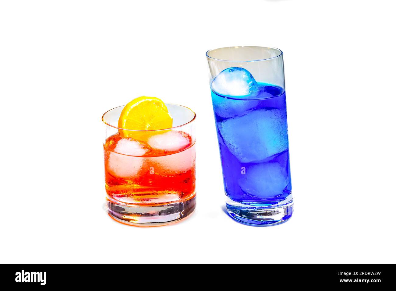 Cocktails rouges et bleus avec glaçons et une tranche de citron isolés dans le studio sur fond blanc Banque D'Images