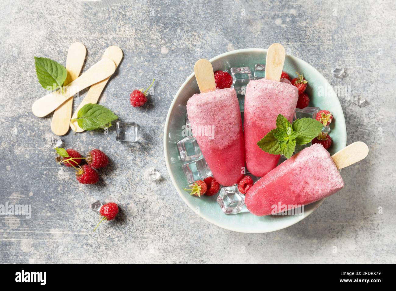 Popsicles de framboise maison avec yaourt et framboises sur un fond de pierre grise. Crème glacée. Dessert d'été. Vue d'en haut. Banque D'Images