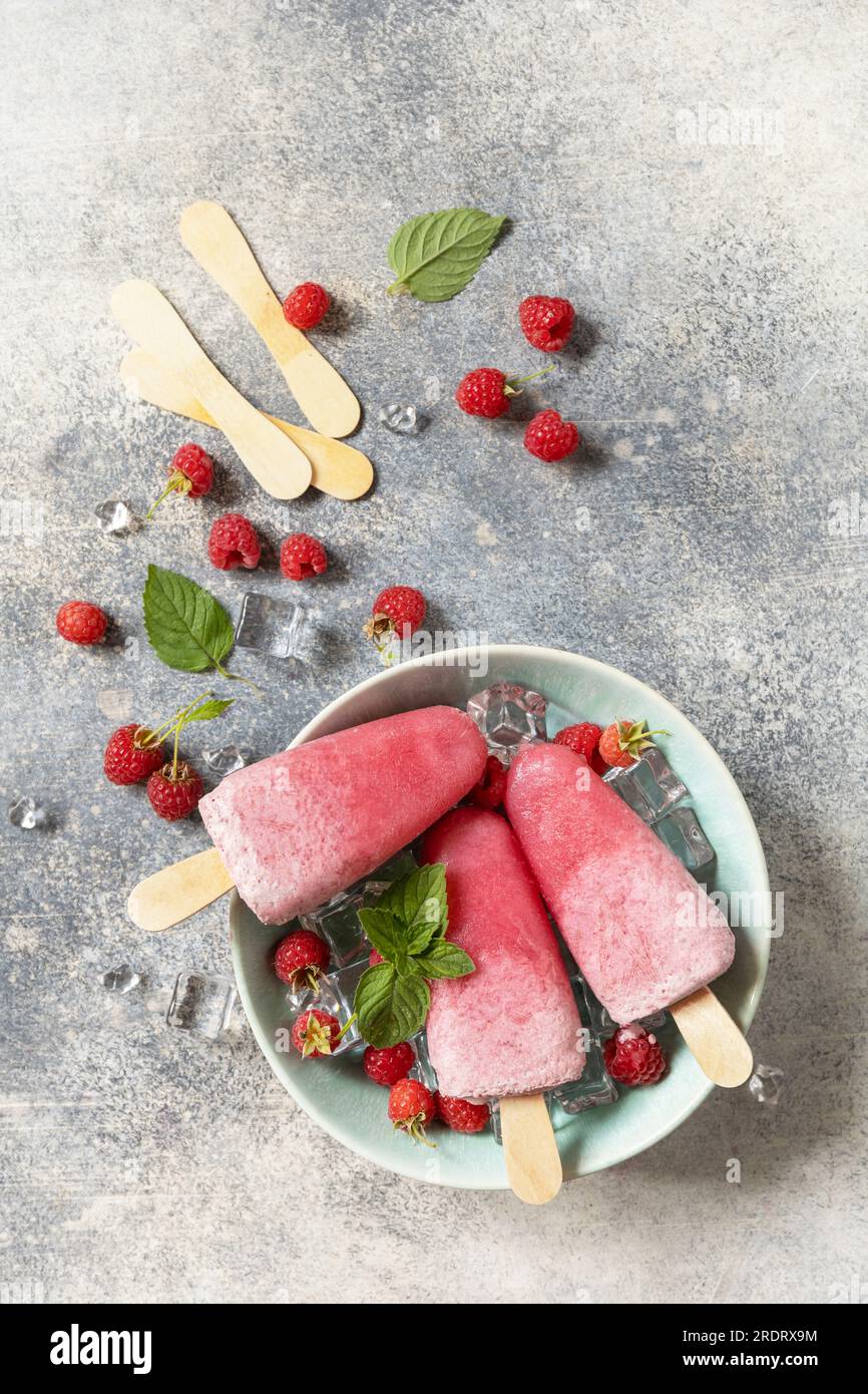 Crème glacée. Dessert d'été. Popsicles de framboise maison avec yaourt et framboises sur un fond de pierre grise. Vue d'en haut. Banque D'Images