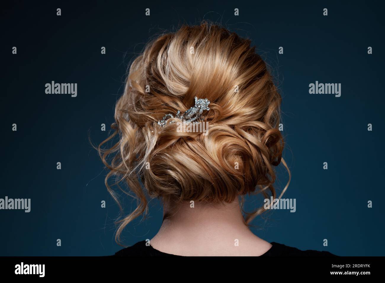 Jeune femme blonde élégante coiffant les cheveux Banque D'Images
