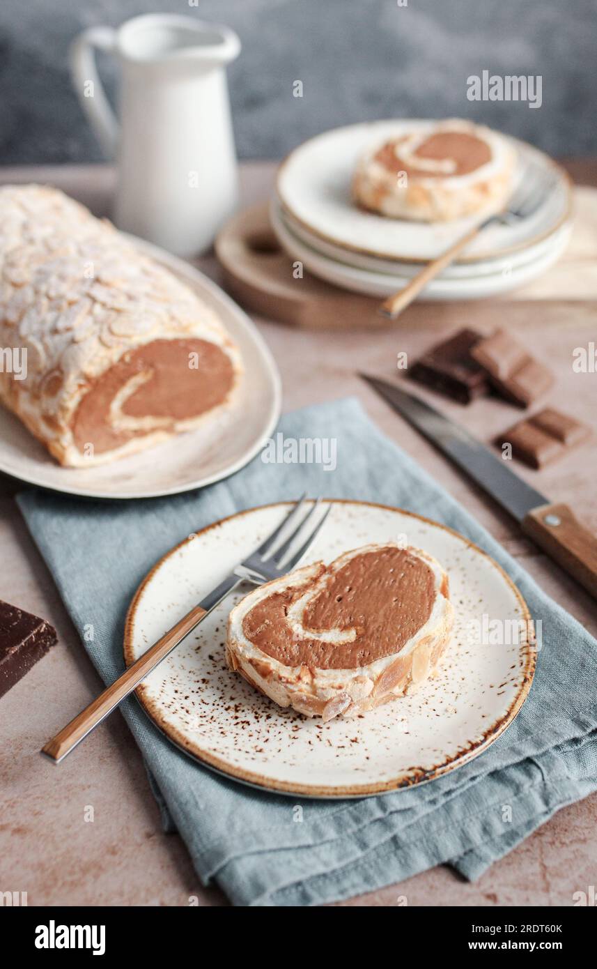 Roulade meringue au chocolat aux amandes. Fond brun, serviette bleue, et fond bleu. Banque D'Images