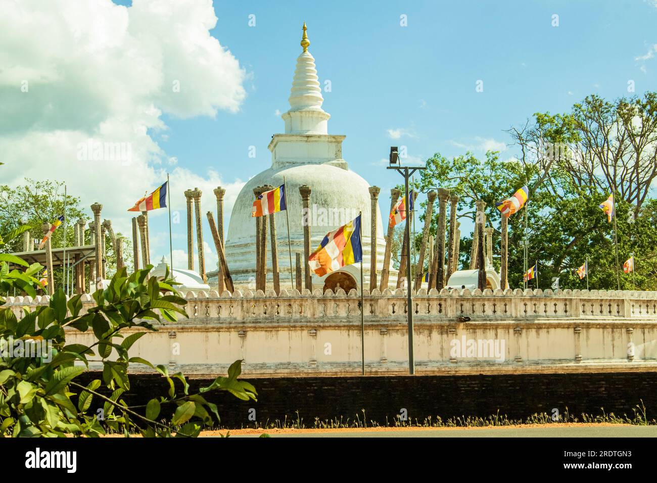 Thuparamaya Stupa blanc avec des drapeaux sur fond de ciel bleu, Anuradhapuraya, Sri lanka. Banque D'Images