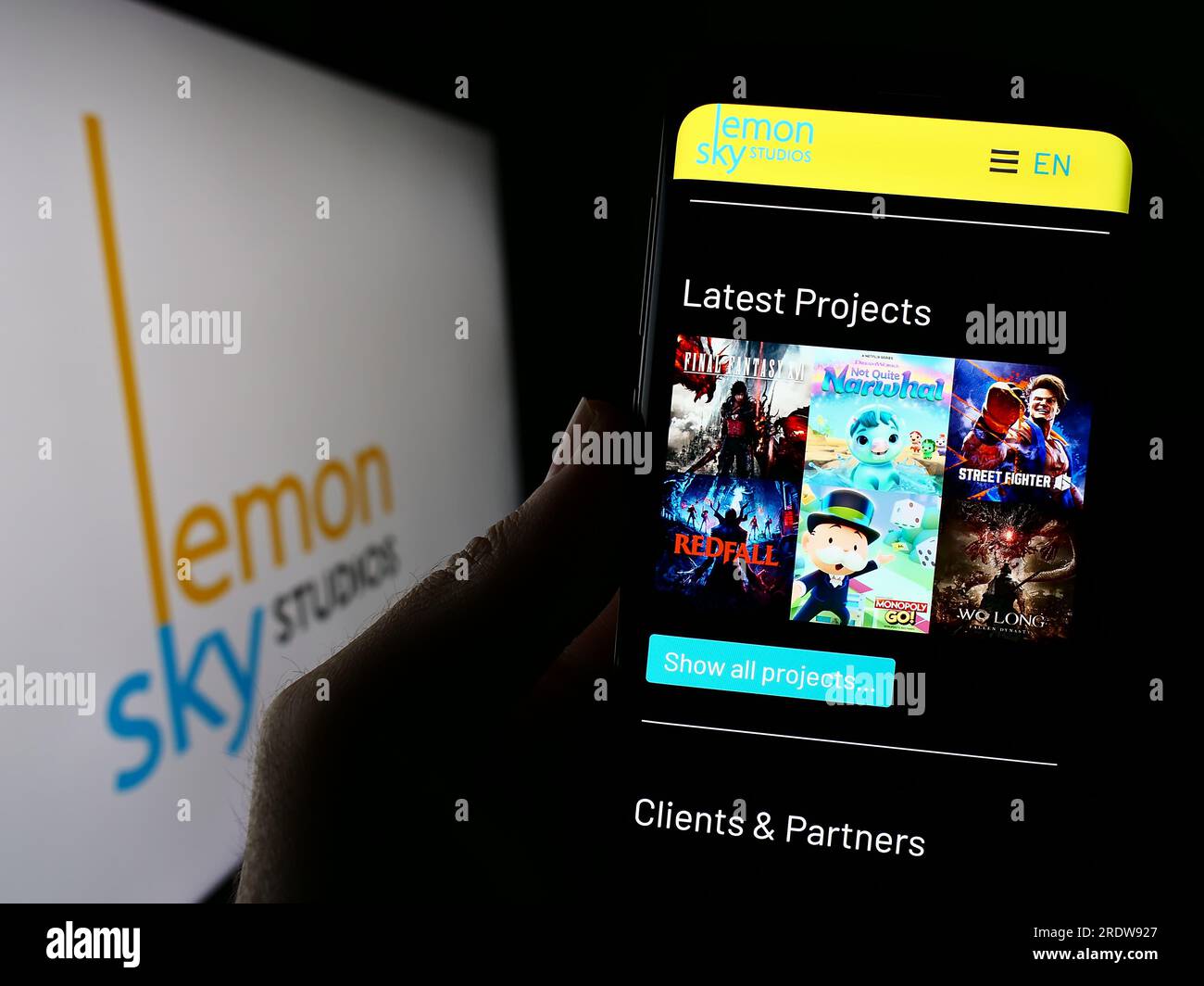Personne tenant un téléphone portable avec le site Web de la société malaisienne de jeux vidéo Lemon Sky Studios à l'écran avec logo. Concentrez-vous sur le centre de l'écran du téléphone. Banque D'Images