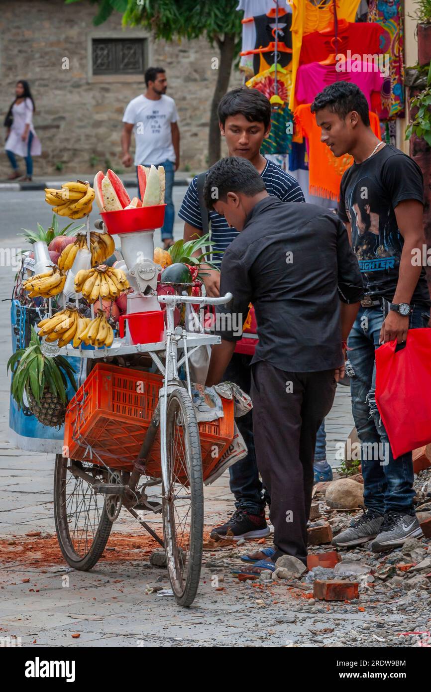 Homme vendant du jus de fruits frais pressé au Népal Banque D'Images