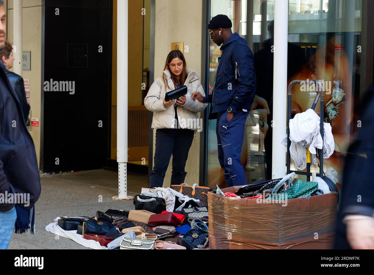 Un vendeur de rue sans licence vendant des sacs à main contrefaits et de faux sacs à main sur Fifth Avenue à Midtown Manhattan, New York. Banque D'Images