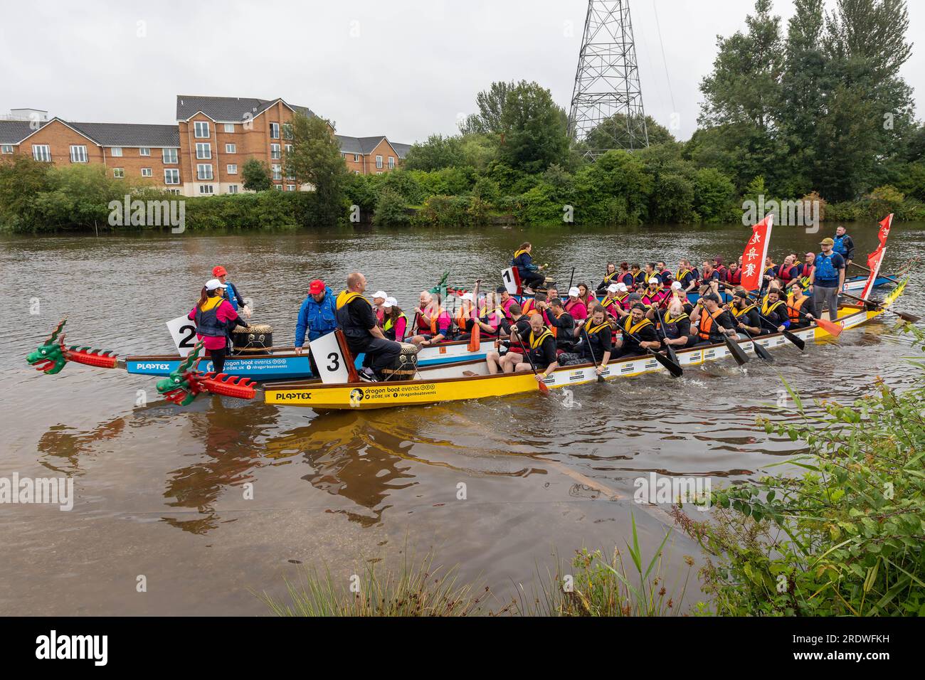 23 juillet 2023 - River Mersey, Warrington, Cheshire, Angleterre - un festival de bateaux-dragons organisé le long de la rivière Mersey à Warrington. Tenu au Rowing Club et malgré la pluie continue tout au long de la journée, un certain nombre de bateaux-dragons se sont affrontés pour trouver un gagnant éventuel. Les bateaux rament en arrière pour arriver au milieu de la rivière. L'événement visait à amasser des fonds pour l'Hospice St Rocco qui a pour objectif de fournir des soins de qualité et un soutien aux personnes et à leurs proches atteints d'une maladie limitant la vie qui vivent dans la région de Warrington pour permettre à chaque personne de trouver le confort, l'espoir, la force et la paix. Banque D'Images