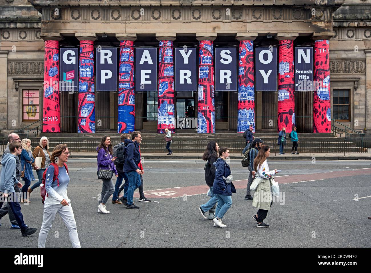 Piétons sur Princes Street se promènent devant la Royal Scottish Academy pour annoncer l'exposition Grayson Perry, qui fait partie du Festival d'Édimbourg 2023. Banque D'Images
