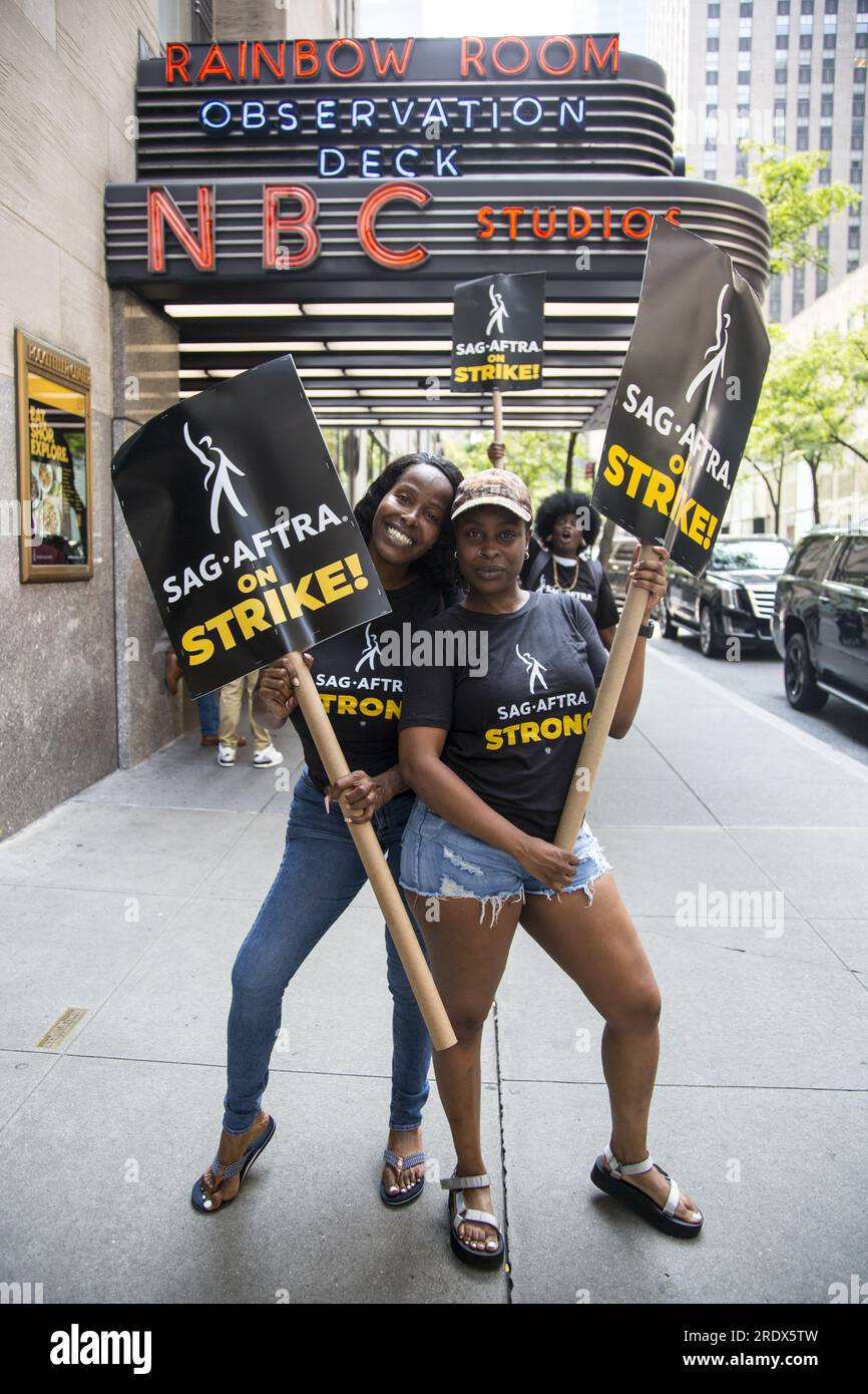 New York City : la grève se poursuit parmi les Writers Guild of America et les membres du syndicat SAG-AFTRA avec des lignes de piquetage dans plusieurs endroits à Manhattan. Des grévistes manifestent devant les studios NBC sur W. 49th Street près du Rockefeller Center, paralysant l'industrie du divertissement. Banque D'Images