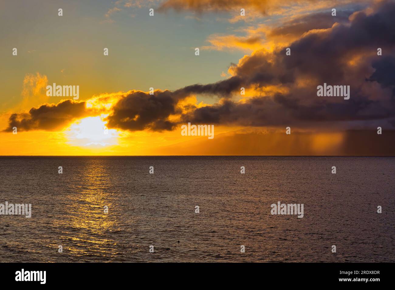 Soleil sur le point de plonger dans l'horizon lors d'une belle soirée sur maui. Banque D'Images