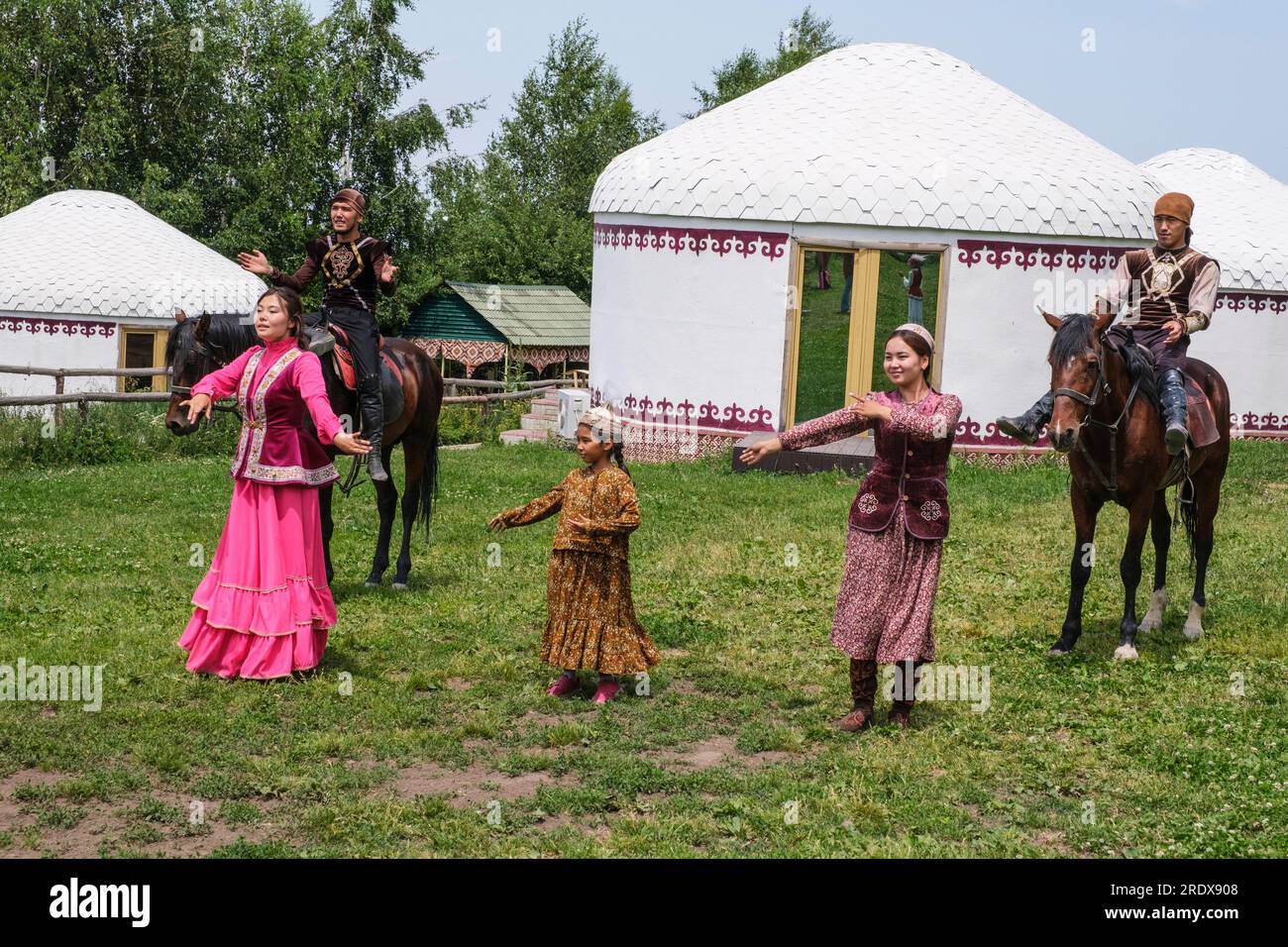 Kazakhstan, village ethno de Huns. Des femmes, des filles et des cavaliers démontrant la danse traditionnelle kazakhe. Banque D'Images