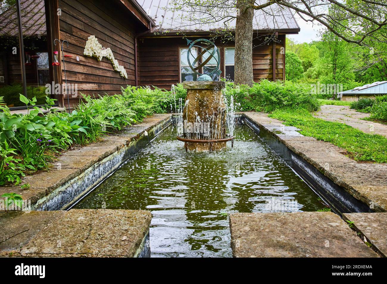 Gros plan de fontaine d'eau fantaisie avec sphère de rotation abstraite avec flèche et canal près de la cabine Banque D'Images