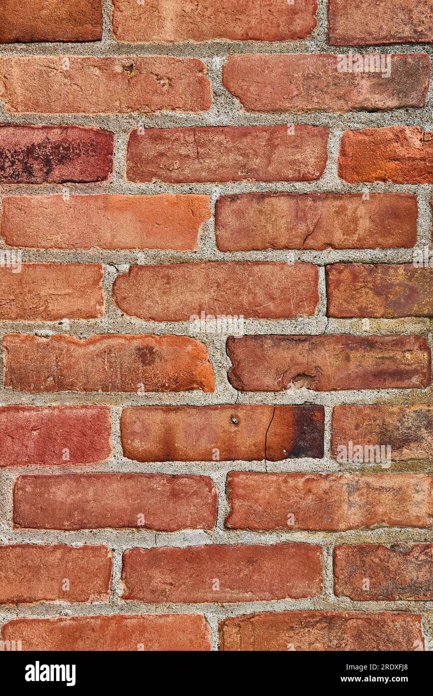 Plan vertical de l'élément d'arrière-plan de mur de briques rouges craquelé et sale ou crasseux Banque D'Images