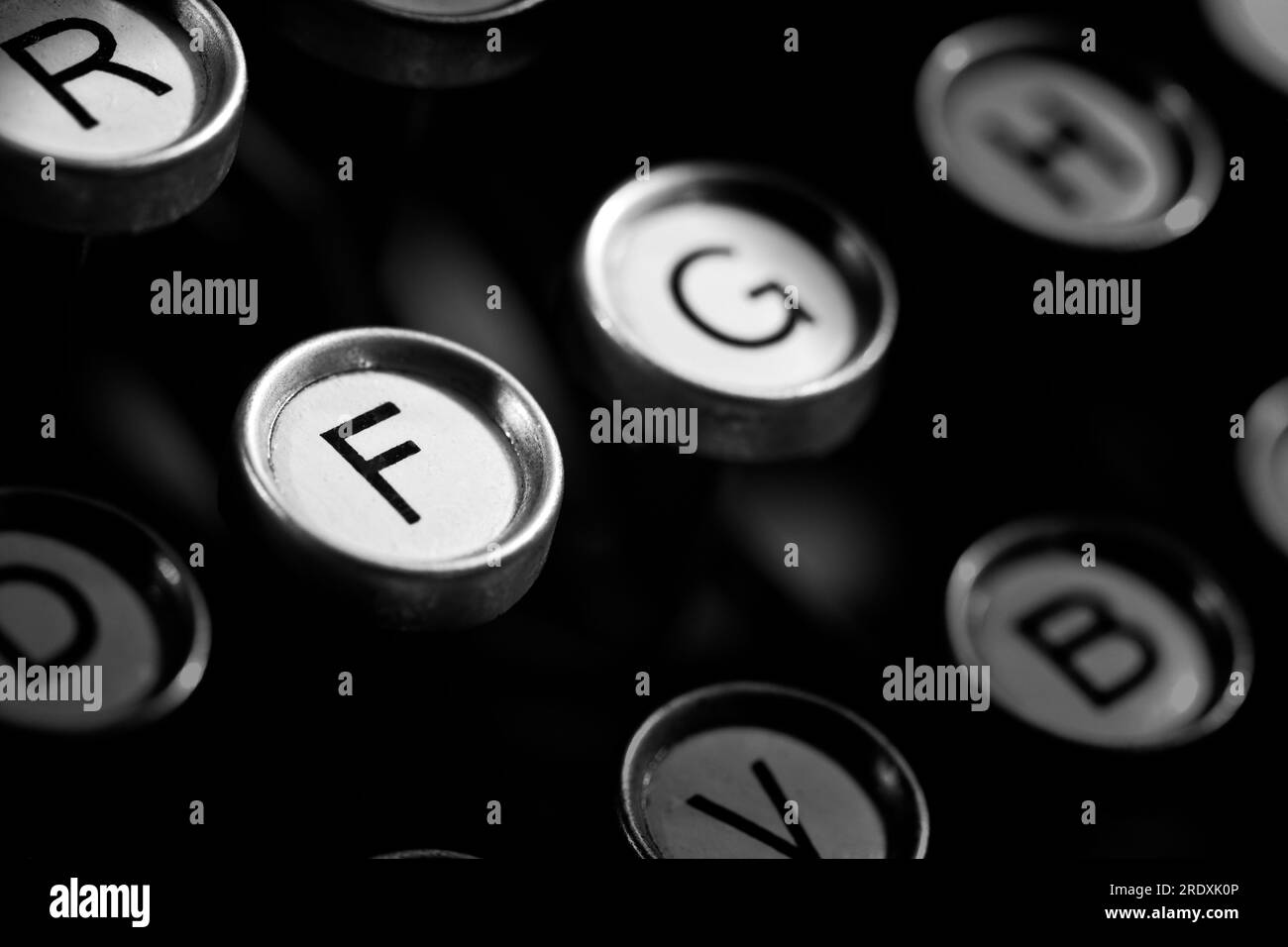 Quelques touches visibles sur une machine à écrire classique des années 1920 avec fond noir riche. Convient aux bureaux d'affaires et aux chambres d'hôtel. Banque D'Images