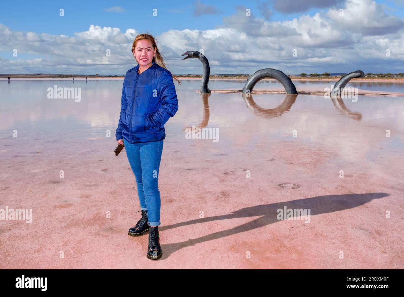 Une jeune touriste asiatique rencontre le monstre du Loch Eel qui vit dans le lac Bumbunga, un lac de sel rose à Lochiel dans le centre-nord de l'Australie méridionale Banque D'Images