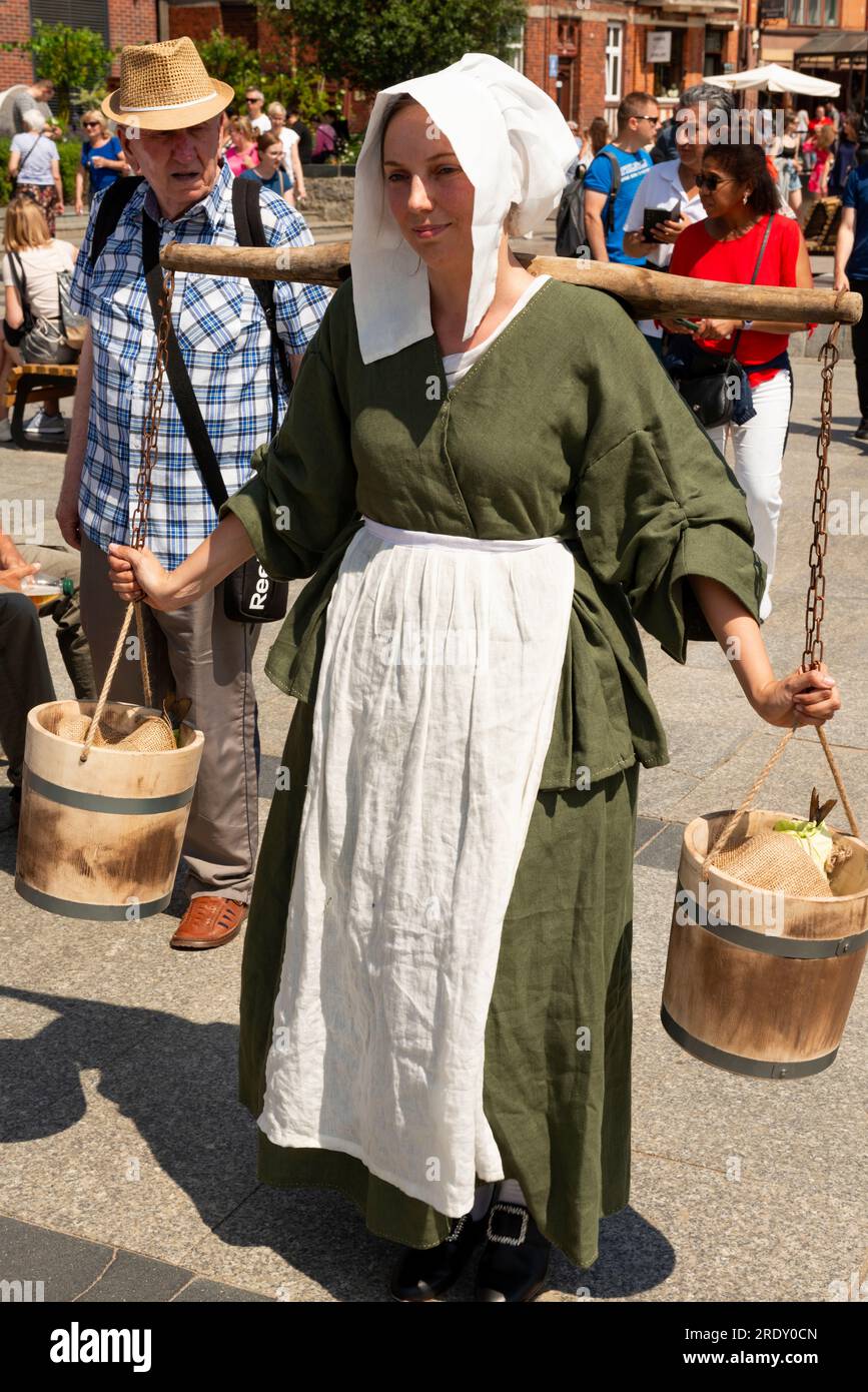 Femme reenacteur comme vendeur de rue médiéval à Targ Rybny ou marché aux poissons dans la vieille ville de Gdansk, Pologne Banque D'Images