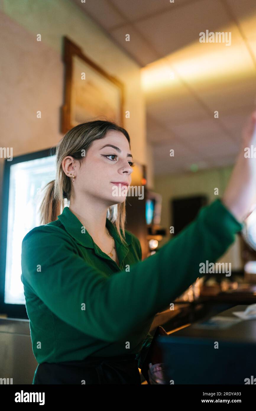 Jeune serveuse travaillant au bar Banque D'Images
