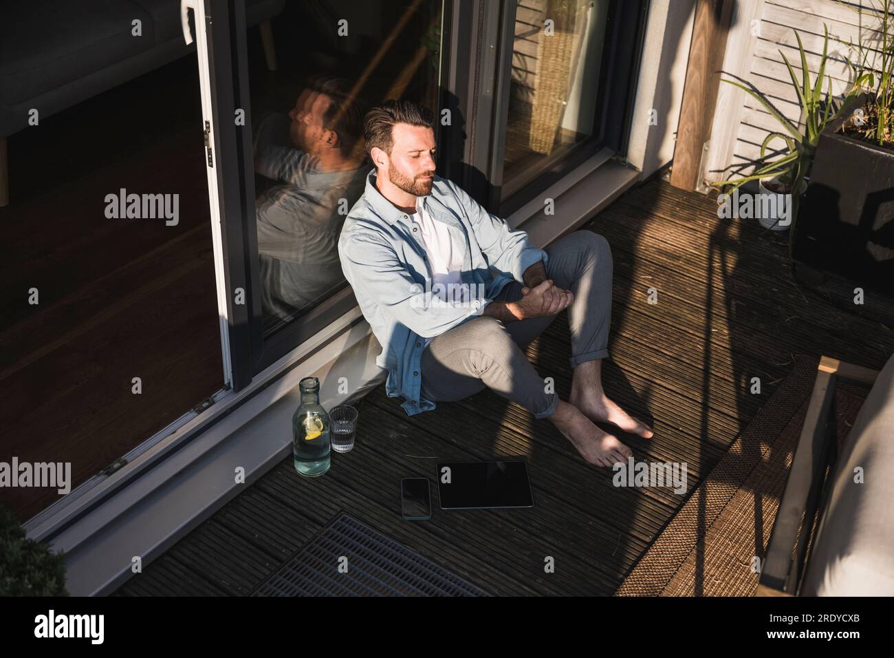 Freelance avec les yeux fermés assis porche Banque D'Images