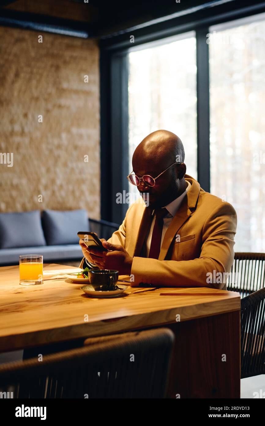 Homme d'affaires utilisant un téléphone intelligent et déjeunant à la table de conférence Banque D'Images