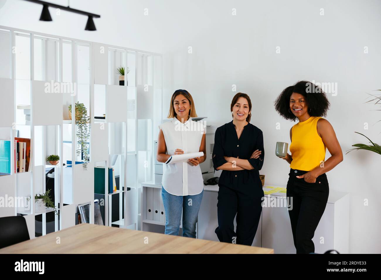 Équipe de femmes d'affaires heureuses debout dans le bureau créatif Banque D'Images