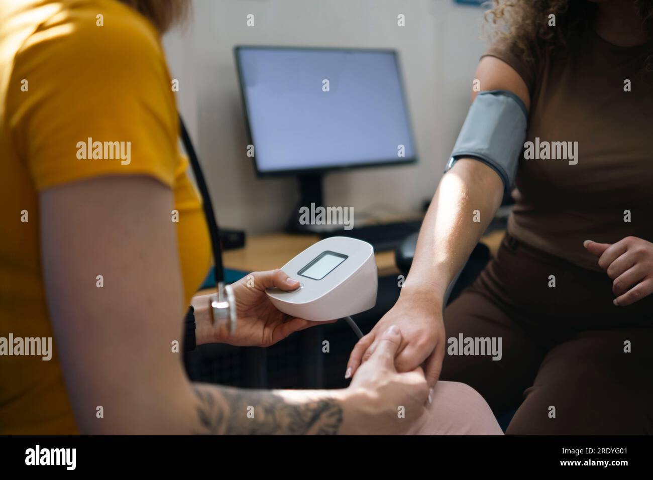 Femme médecin vérifiant la pression artérielle du patient à la clinique Banque D'Images