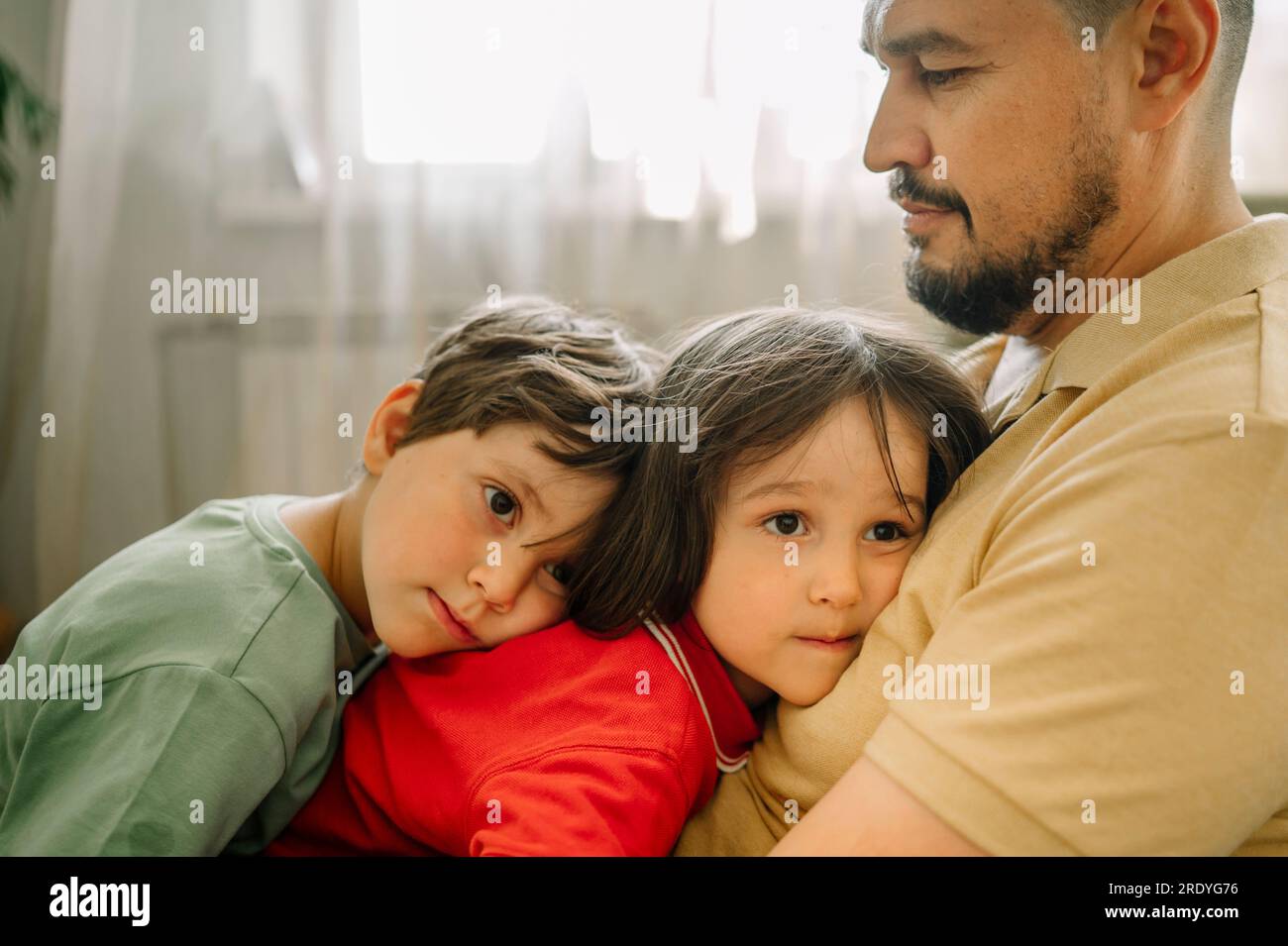 Père embrassant les enfants à la maison Banque D'Images