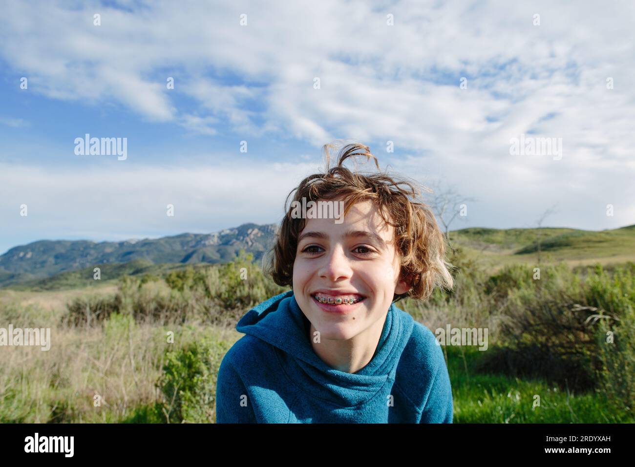 Jeune fille adolescente avec des bretelles sourit alors qu'à l'extérieur dans la nature Banque D'Images