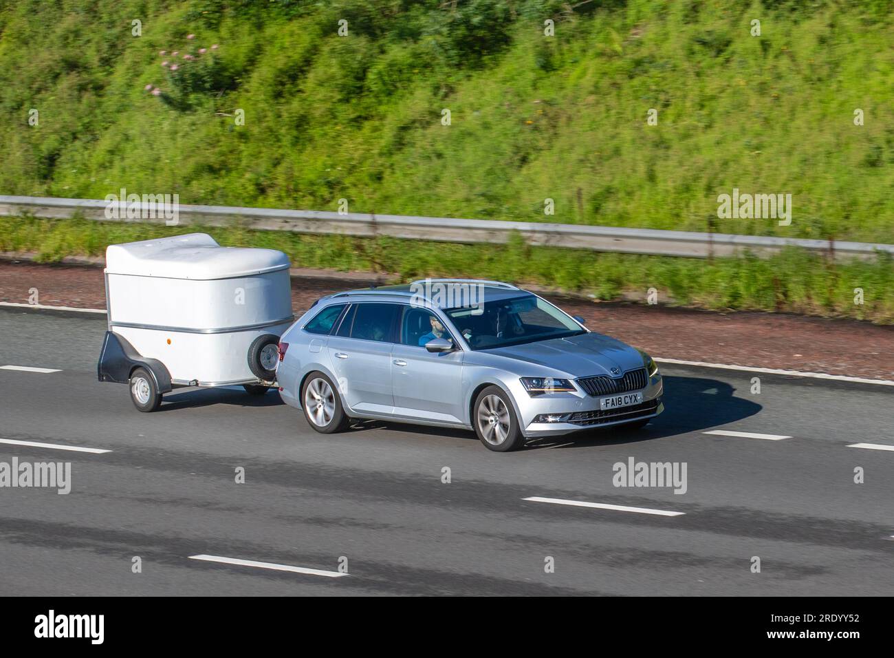 2018 Skoda Superb se L Executive TDI S-A TDI 150 DSG7 SCR Auto Start/Stop Silver car Estate Diesel 1968 cc, remorquage petite caravane de pod voyageant à grande vitesse sur l'autoroute M6 dans le Grand Manchester, Royaume-Uni Banque D'Images