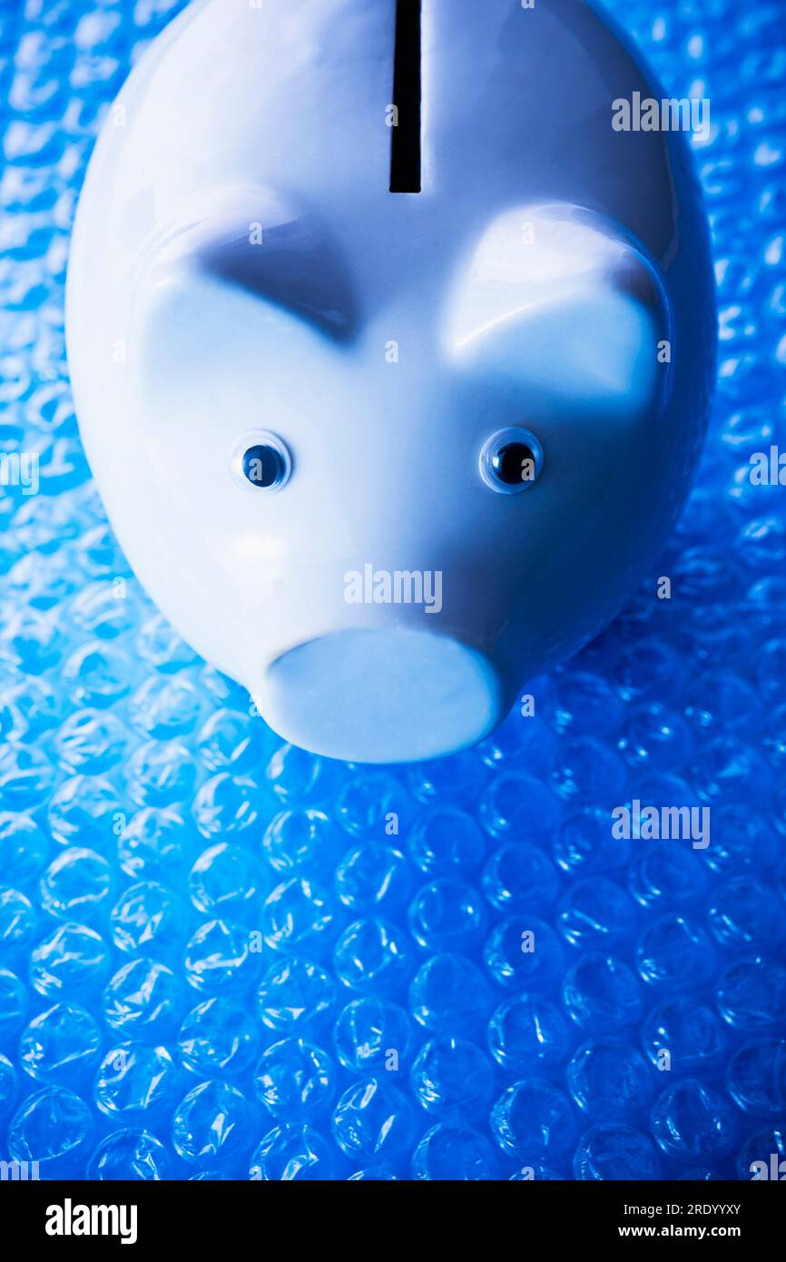 Tirelire en porcelaine blanche sur papier bulle bleu Banque D'Images