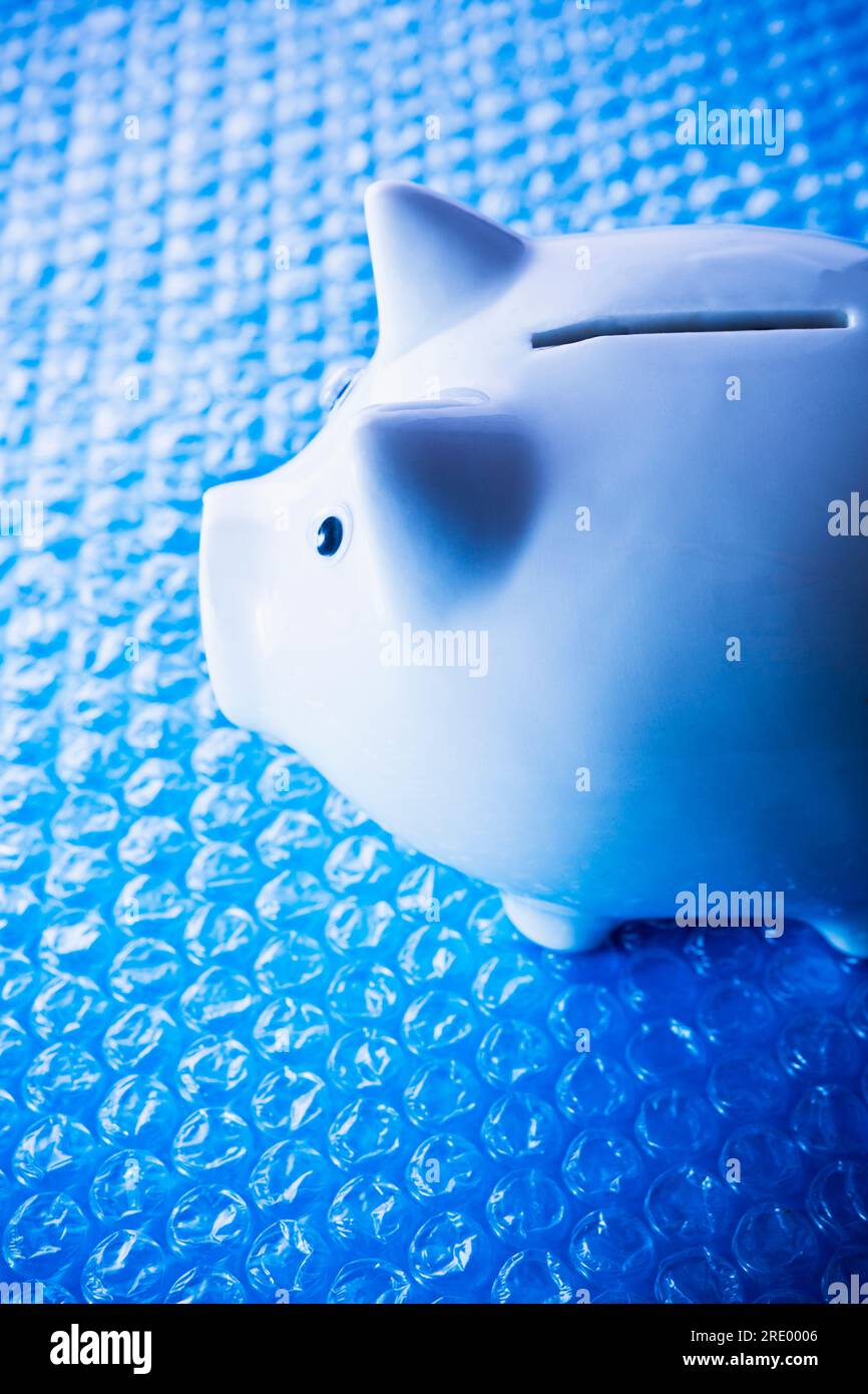 Tirelire en porcelaine blanche sur papier bulle bleu Banque D'Images